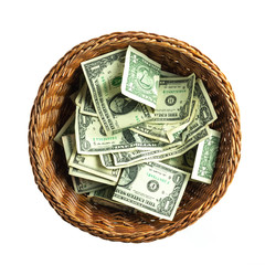 brown wicker donation basket filled with US one and five doallar bills isolated on a white background