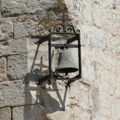 Antica campanella di una chiesa cattolica appesa fuori dalle mura