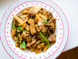 Thai food-Stir fried flat rice Noodles with sweet soy sauce (Pad See Ew) vegetable and minced pork as close-up, a famous food in Thailand.
