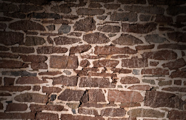 Old masonry wall using irregular stones lit from above