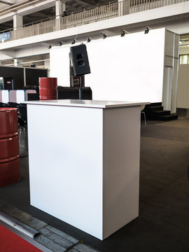 Blank mock up creative exhibition stand design with shapes. Booth template, Empty exhibition kiosk, with copy space, futuristic interior suspending lighting fixtures, computer and tv screen.