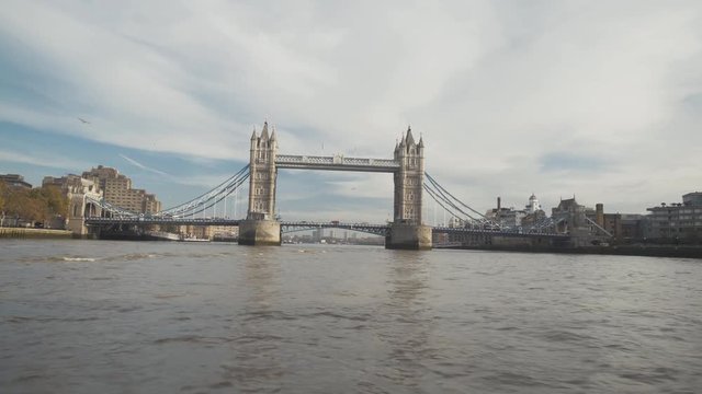 Moving shot of Tower Bridge point of view from a boat cruise tourists sailing on Thames River on a sunny day