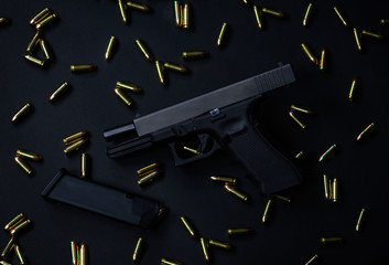 Pistol and ammunition on black background