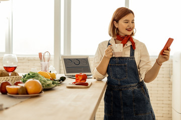 Red-haired young pretty girl with a red necktie looking pleased