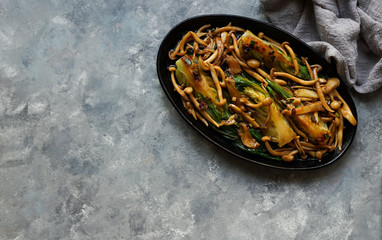Bok choy o pak choi cabbage with shimeji mushrooms and Oyster sauce, garlic, typical asian japanese food, top view, flat lay, copy space