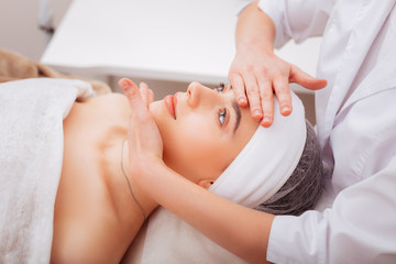 Obraz na płótnie Canvas Nice young woman enjoying her facial massage