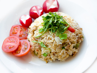 Delicious Thai traditional food, spicy fried Jasmine rice with chilli shrimp paste dip and vegetables on white plate.