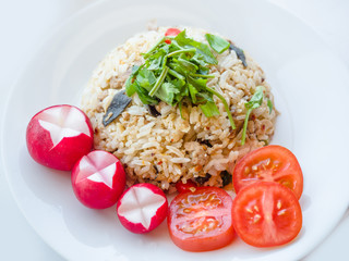 Delicious Thai traditional food, spicy fried Jasmine rice with chilli shrimp paste dip and vegetables on white plate.