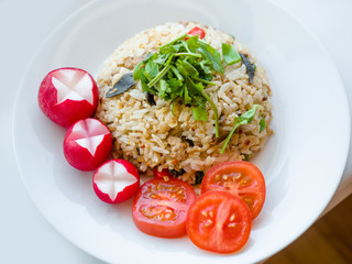 Delicious Thai traditional food, spicy fried Jasmine rice with chilli shrimp paste dip and vegetables on white plate.