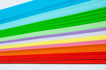 Colored paper on a white background, rainbow colors.