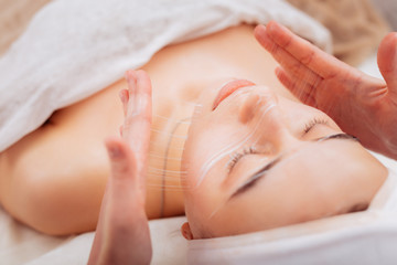 Nice pleasant woman having a special cream applied on her skin