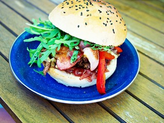 Homemade whole big fresh burger with cheese and bacon on wooden table