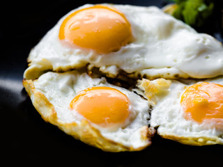 Thai styled perfectly crispy street food fried eggs on black background