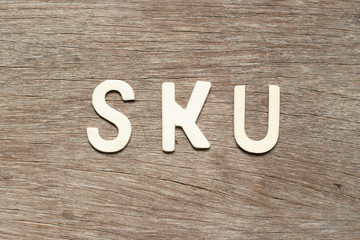 Alphabet letter in word SKU (abbreviation of stock keeping unit) on wood background