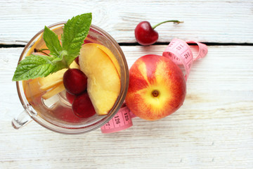 Menu diet plan or program, a glass of cocktail berries, tape measure, dumbbells and diet food fresh fruits . Weight loss and the concept of detoxification