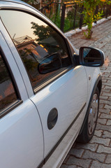 Fototapeta premium Close up of car mirror with reflection of behind the car.