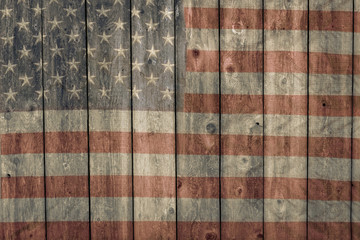 faded american flag painted on the side of an old weathered wooden barn  © Kort Feyerabend