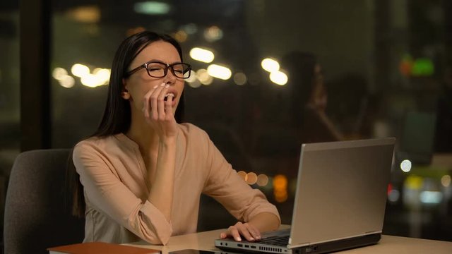 Bored woman working on laptop, exhausted with overtime, lack of motivation