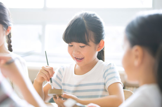 絵具の筆で色を塗る女の子