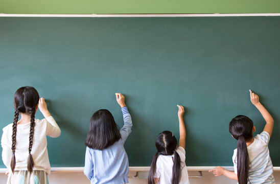 黒板に文字を書こうとする女の子4人