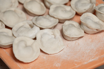 Fototapeta na wymiar Homemade dumplings from dough and minced meat, preparation ravioli, with minced meat close up.