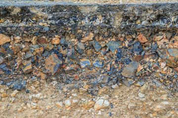The layer of asphalt road with soil and rock after landslide.