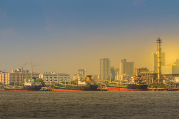 Obraz premium View of Bangkok Port Authority of Thailand or Klong Toey port along Chao Phraya river in Bangkok,Thailand. Heavy crane tool in ship port and container yard use for import and export.