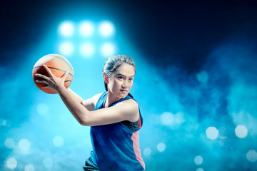 Excited asian girl basketball player defending the ball from opponent on the basketball court