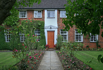 Fototapeta na wymiar large brick house with shady English garden