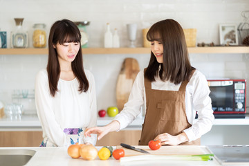 attractive asian women cooking in kitchen