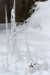 Bloody dead snowman impaled on a sharp icicle during a winter storm