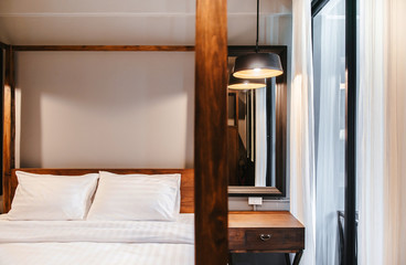 Asian contemporary vintage hotel bedroom with four poster bed, white sheet, pillows