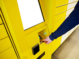 Electronic Locker, Yellow automated parcel terminal (parcel locker, post terminal, E-Locker) on the street with empty screen for mockup, home delivery. 