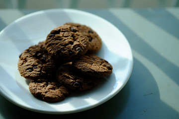 Close up Chocolate cookies in white dish and Light from the window