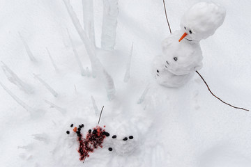 Bloody dead snowman impaled on a sharp icicle during a winter storm