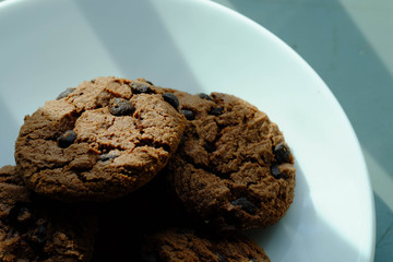 Close up Chocolate cookies in white dish and Light from the window