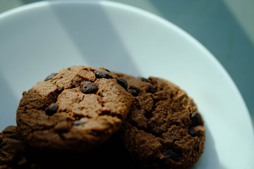 Close up Chocolate cookies in white dish and Light from the window