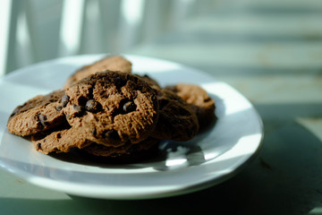 Close up Chocolate cookies in white dish and Light from the window