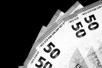 Fifty euro banknotes on a dark background close up. Black and white