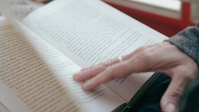 Close up of a woman's hand flipping a page while reading a book
