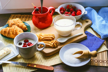 fresh breakfast foods. milk yogurt, croissants and frozen berries.