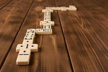 The concept of games of dominoes. Playing dominoes on a wooden table.