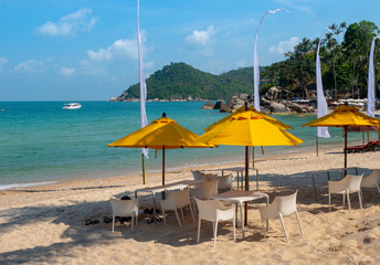 Sea view and yellow umbrellas at island sand beach line