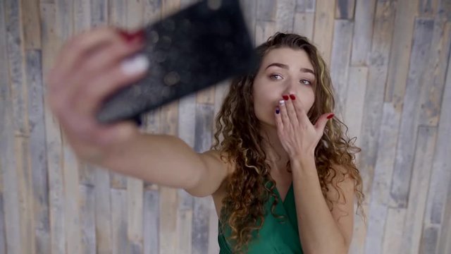 Indoor portrait of a sexy girl posing for selfie on smartphone.