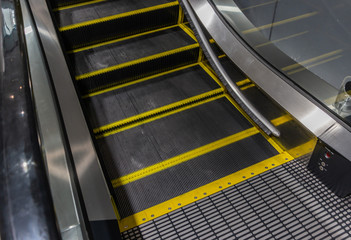 Moving up staircase. electric escalator. Close up to escalators. Close up floor platform. yellow bands. metal line steel.