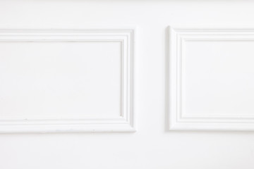 Beautiful ornate white decorative plaster mouldings in studio. The white wall is decorated with...