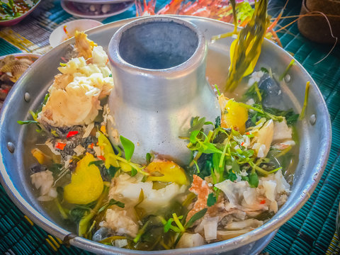 Tom yum Sleepy goby, Marbled sleeper (Oxyeleotris marmorata) fish in hot pot boiled with herb broth. Tom yum or tom yam is a type of hot and sour Thai soup with fragrant spices and herbs in the broth.