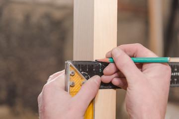 Measure with a coal ruler in the woodwork. Measuring tool. Draw on wood. Corner ruler