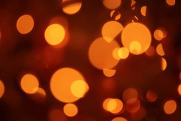 abstract blurred glowing light particles of shades of light gold and red