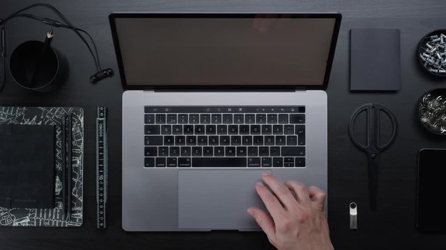 Male hands typing laptop on black clean minimalistic table with top view, gestures and finger movements